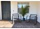 Inviting front porch featuring black rocking chairs, a palm tree, and a dark front door at 3117 Shady Pine Ave, Winter Park, FL 32792