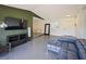 Bright living room with stylish blue couch, TV on an olive accent wall, and gray flooring at 3117 Shady Pine Ave, Winter Park, FL 32792