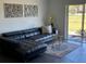 Comfortable living room with a black leather sectional, bright art, and patio door at 3117 Shady Pine Ave, Winter Park, FL 32792