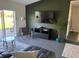 Spacious living room with black entertainment center, slider to patio, and modern decor at 3117 Shady Pine Ave, Winter Park, FL 32792