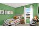 Vibrant ' bedroom with a playful bedspread, window views, and green accent walls at 3456 Costello Cir, Winter Haven, FL 33884