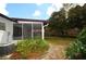 View of the backyard featuring a screened-in patio and lush landscaping at 380 Banyan Dr, Maitland, FL 32751