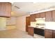 Traditional kitchen with wooden cabinetry, white appliances, tile flooring, and decorative wallpaper border at 380 Banyan Dr, Maitland, FL 32751