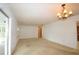 Bright living room featuring carpet flooring, neutral walls, and a view to screened patio at 380 Banyan Dr, Maitland, FL 32751