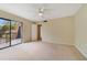 Bright bedroom with plush carpeting, fan, and sliding door access to private balcony at 4036 Shannon Brown Dr, Orlando, FL 32808