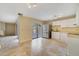 The open-concept kitchen features tile flooring, stainless steel refrigerator, and white cabinetry at 4036 Shannon Brown Dr, Orlando, FL 32808