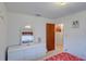 Well-lit bedroom with a dresser, decorative mirror, and access to an en-suite bathroom at 4155 Westgate Rd, Orlando, FL 32808