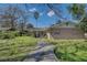 Exterior front view of a single-story home with a pathway and mature landscaping at 4155 Westgate Rd, Orlando, FL 32808