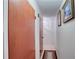 Hallway featuring tile flooring, white walls, and decorative wall art leading to different rooms of the house at 4155 Westgate Rd, Orlando, FL 32808
