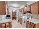 Cozy kitchen with white appliances, wood cabinets, and an open dining area at 4155 Westgate Rd, Orlando, FL 32808