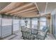 Cozy enclosed patio with exposed beam ceiling, tile floor, and a metal table with cushioned chairs at 4155 Westgate Rd, Orlando, FL 32808