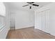 This bedroom includes a closet, ceiling fan, wood-look floors and view to the bath at 4536 San Sebastian Cir, Orlando, FL 32808