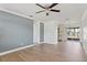 Spacious living room featuring wood-look flooring, modern ceiling fan, and natural light at 4536 San Sebastian Cir, Orlando, FL 32808