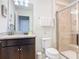 Bathroom featuring granite countertops, dark cabinets, a toilet, and a tiled shower with glass door at 4594 Terrasonesta Dr, Davenport, FL 33837