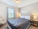 Bedroom featuring a tufted headboard bed, with light gray walls, and view of the yard at 4594 Terrasonesta Dr, Davenport, FL 33837