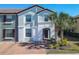 Charming two-story townhome featuring a light blue facade, red tile roof, and well-maintained landscaping at 4594 Terrasonesta Dr, Davenport, FL 33837
