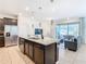 Open-concept kitchen featuring a large center island, stainless steel appliances, and a seamless connection to the living area at 4594 Terrasonesta Dr, Davenport, FL 33837