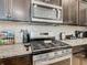 Kitchen area featuring a stainless steel gas stove, granite countertops, and dark cabinetry at 4594 Terrasonesta Dr, Davenport, FL 33837