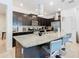 Stylish kitchen with a granite island, dark wood cabinets, and modern pendant lighting at 4594 Terrasonesta Dr, Davenport, FL 33837