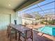 Poolside covered patio featuring a dining table, chairs, and lounge chairs for relaxing outdoors at 4594 Terrasonesta Dr, Davenport, FL 33837