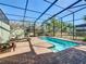 Screened-in pool area with brick pavers, lounge chairs, and lush landscaping at 4594 Terrasonesta Dr, Davenport, FL 33837