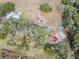 Aerial view of a home and vineyard from above, showcasing red roofed buildings, a pond and the planted vines at 5117 Cr 316A, Bushnell, FL 33513