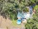 Aerial view of property featuring a pool, home, and driveway surrounded by lush trees at 5117 Cr 316A, Bushnell, FL 33513