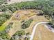 An aerial view of a vineyard estate, showcasing the lush landscape, pond, and winding road at 5117 Cr 316A, Bushnell, FL 33513