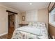 Cozy bedroom featuring light-colored walls, shutters on the windows, and wood flooring in adjacent space at 5117 Cr 316A, Bushnell, FL 33513