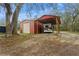 Outdoor RV storage area featuring a red shed and a covered shelter for recreational vehicles at 5117 Cr 316A, Bushnell, FL 33513