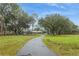 Beautiful single-story home with mature trees lining the driveway on a large grassy property at 5117 Cr 316A, Bushnell, FL 33513
