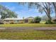 Inviting single-story home with a metal roof, mature trees, and a spacious front yard at 5117 Cr 316A, Bushnell, FL 33513