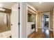Hallway featuring white trim, wood floors, laundry, and adjacent bathroom and bedroom areas at 5117 Cr 316A, Bushnell, FL 33513