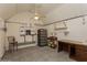 Versatile room featuring white walls, a ceiling fan, storage racks, and a desk, perfect for a workshop or home office at 5117 Cr 316A, Bushnell, FL 33513
