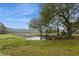Scenic view of a serene pond with a wooden dock and lush green surroundings and mature trees at 5117 Cr 316A, Bushnell, FL 33513