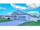 View of home featuring a two-car garage, covered porch, and a beautiful driveway and manicured lawn at 523 Cascading Creek Ln, Winter Garden, FL 34787