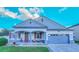Charming single-story home featuring a covered porch, attached two-car garage, and well-manicured lawn at 523 Cascading Creek Ln, Winter Garden, FL 34787