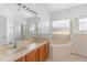 Bathroom featuring double sinks, soaking tub, walk-in shower, and natural light from a bright window at 536 Kilimanjaro Dr, Kissimmee, FL 34758