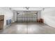 View of a spacious garage with a metal garage door at 536 Kilimanjaro Dr, Kissimmee, FL 34758