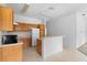 Efficient kitchen featuring wooden cabinets, white appliances, and an open breakfast bar, perfect for casual dining at 536 Kilimanjaro Dr, Kissimmee, FL 34758