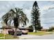 Exterior view of a single-story home with a large tree and well-maintained landscaping. Red truck and car in driveway at 5371 Tribune Dr, Orlando, FL 32812