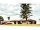 Charming single-story home featuring a well-maintained lawn and mature landscaping, plus a pair of chairs out front at 5371 Tribune Dr, Orlando, FL 32812