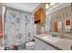 Well-lit bathroom with seashell-themed shower curtain and updated vanity at 551 Majesty Dr, Davenport, FL 33837