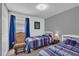 Bedroom with two beds, a wooden rocking chair, and natural light from a window at 551 Majesty Dr, Davenport, FL 33837