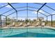 Sparkling screened-in pool area with lounge chairs offering a serene outdoor retreat at 551 Majesty Dr, Davenport, FL 33837