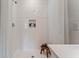 Modern walk-in shower features white tiles, a built-in niche, and a small wooden bench for added convenience at 5852 Galloping Dr, Apopka, FL 32712