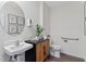 Stylish half bathroom features a modern sink, wooden cabinet, round mirror, and convenient grab bar at 5852 Galloping Dr, Apopka, FL 32712