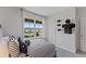 Well-lit bedroom with football decor, stylish striped bedding, and a large window with neighborhood views at 5852 Galloping Dr, Apopka, FL 32712