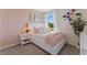 Charming bedroom featuring a pink color scheme, bright window, and floral wall decor, creating a cheerful ambiance at 5852 Galloping Dr, Apopka, FL 32712
