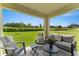 Relaxing covered patio with comfortable seating and a view of the green backyard at 5852 Galloping Dr, Apopka, FL 32712